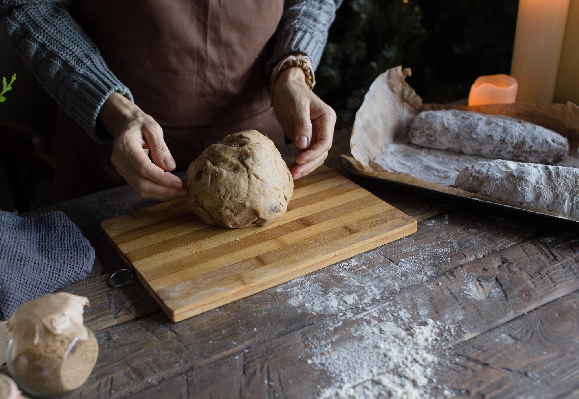 close-up of hands kneading dough in warm kitchen