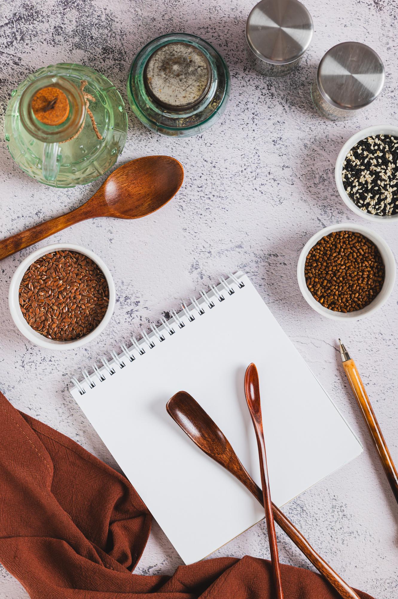 studio table with herbs, notebooks and tasting spoons